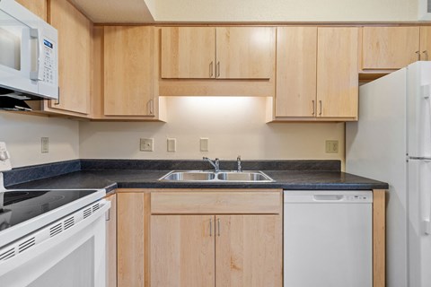 A kitchen with wooden cabinets and white appliances.