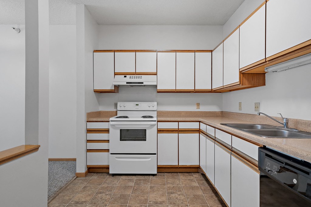 a kitchen with white cabinets and a stove and a sink