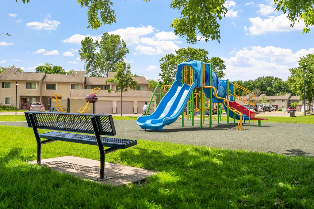 a playground with a blue slide in a park