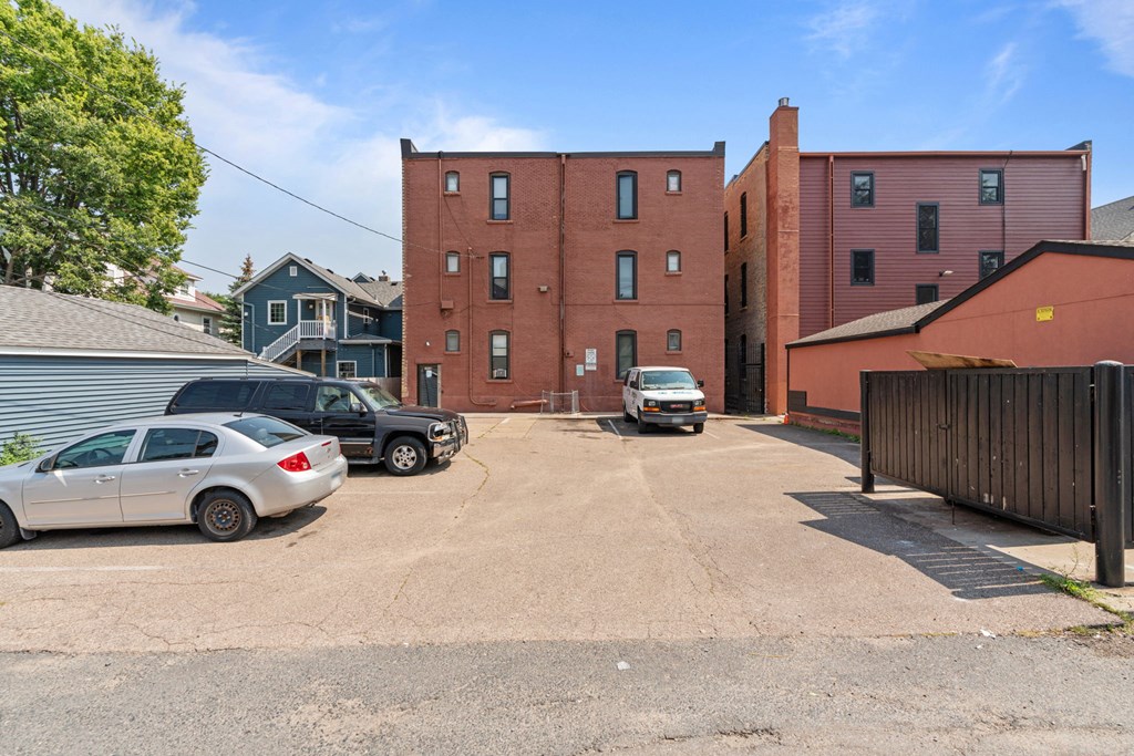 a large red brick building with cars parked in a parking lot