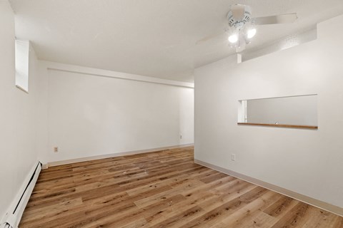 the living room and dining room with wood flooring and white walls