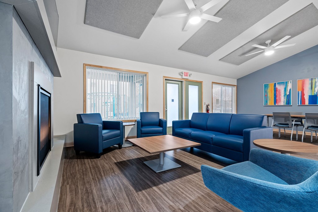 a living room with blue couches and chairs and a table