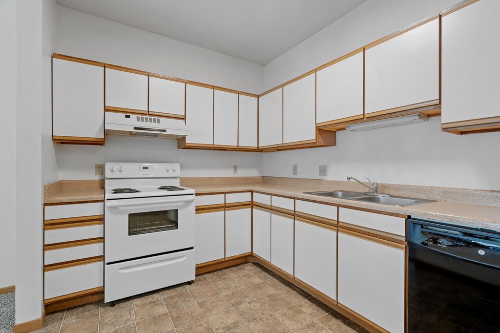 a kitchen with white cabinets and a stove and a sink