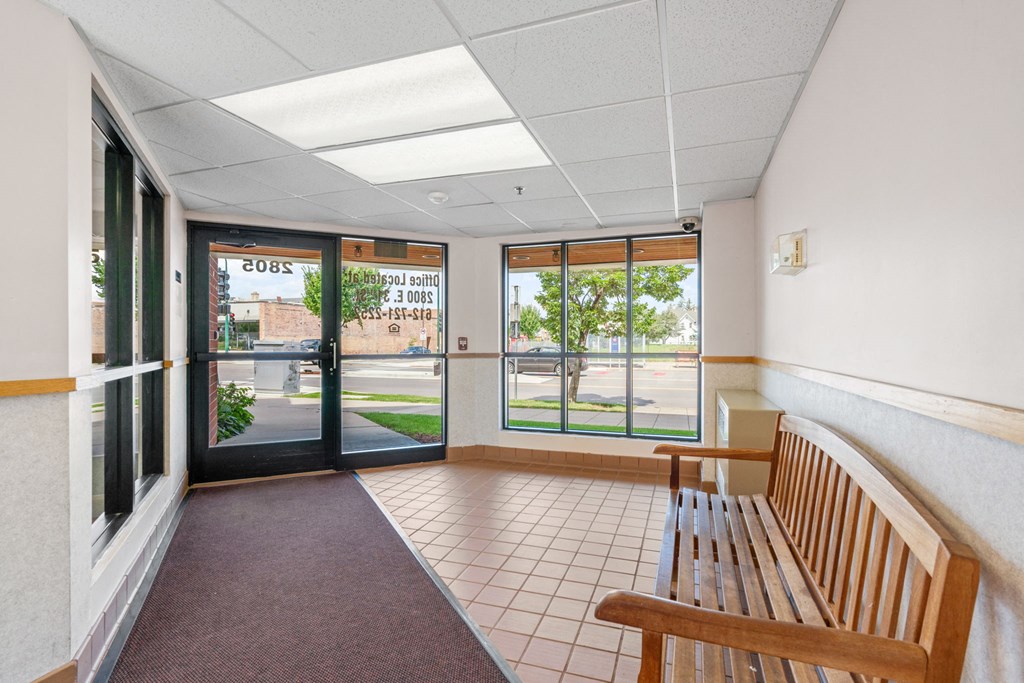 a lobby with a bench and glass doors