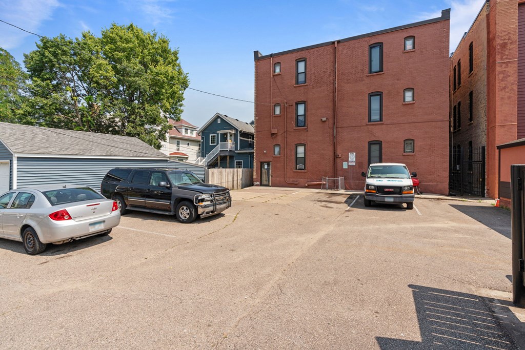a large parking lot with cars in front of a brick building