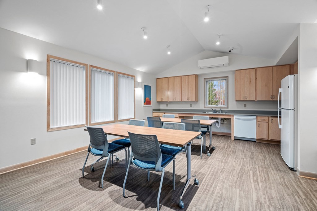 a conference room with a kitchen and a table with chairs