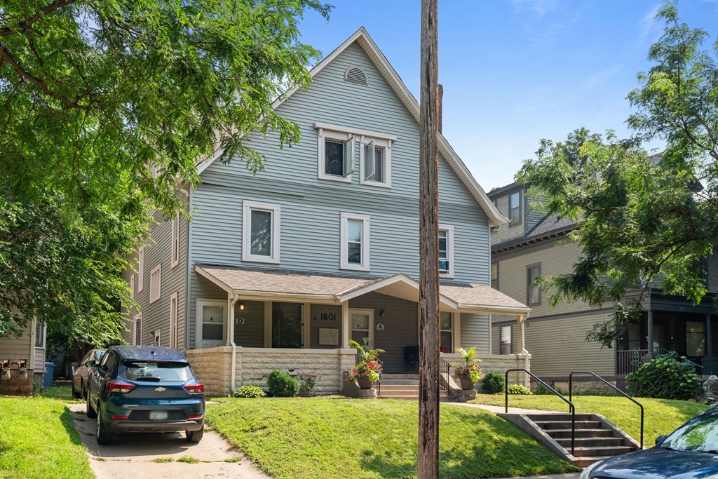 a blue house with a car parked in front of it