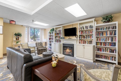 a living room with a fireplace and book shelves