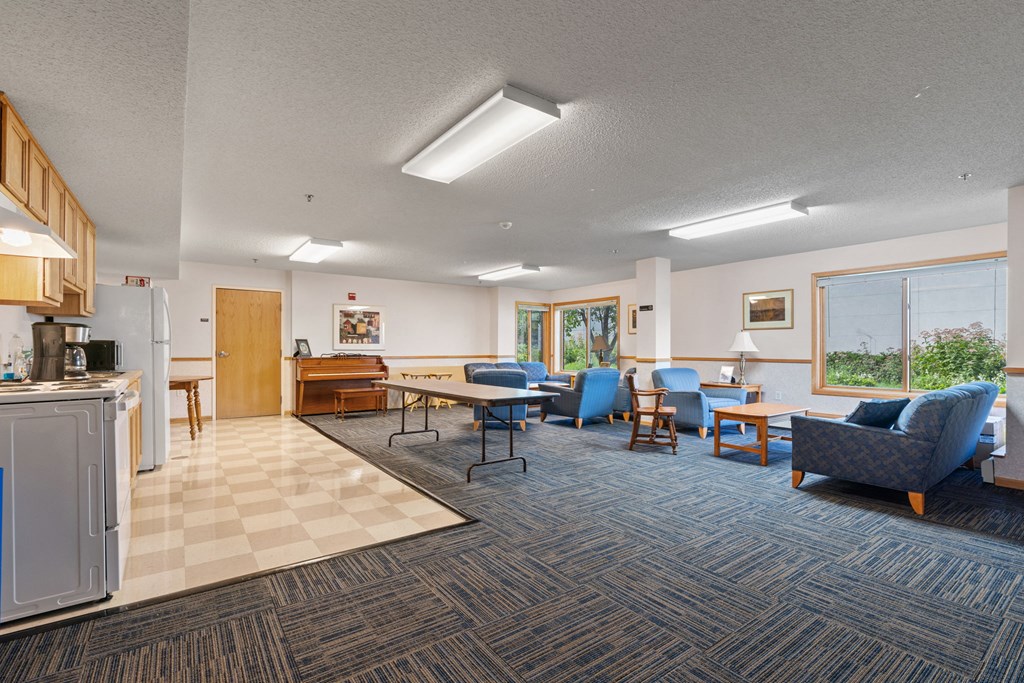 a living room with couches and chairs and a kitchen with a table