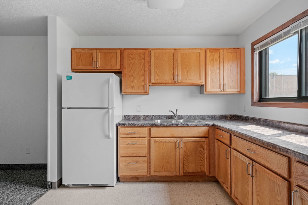 a kitchen with wooden cabinets and a white refrigerator
