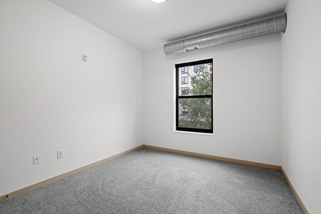 an empty room with a window in the corner