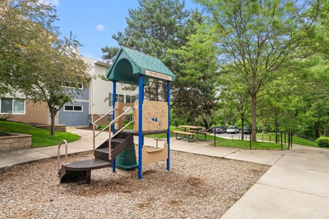 a playground with a playset and a slide in a park