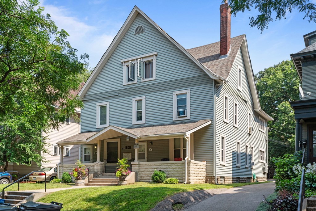 a blue house with a porch and a lawn