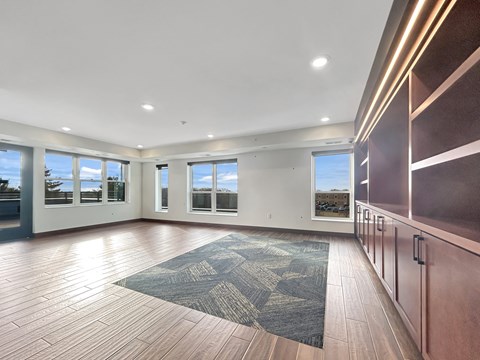 an empty living room with wood flooring and large windows