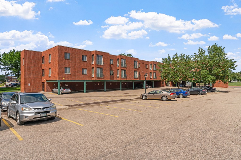 a parking lot with cars in front of a brick building
