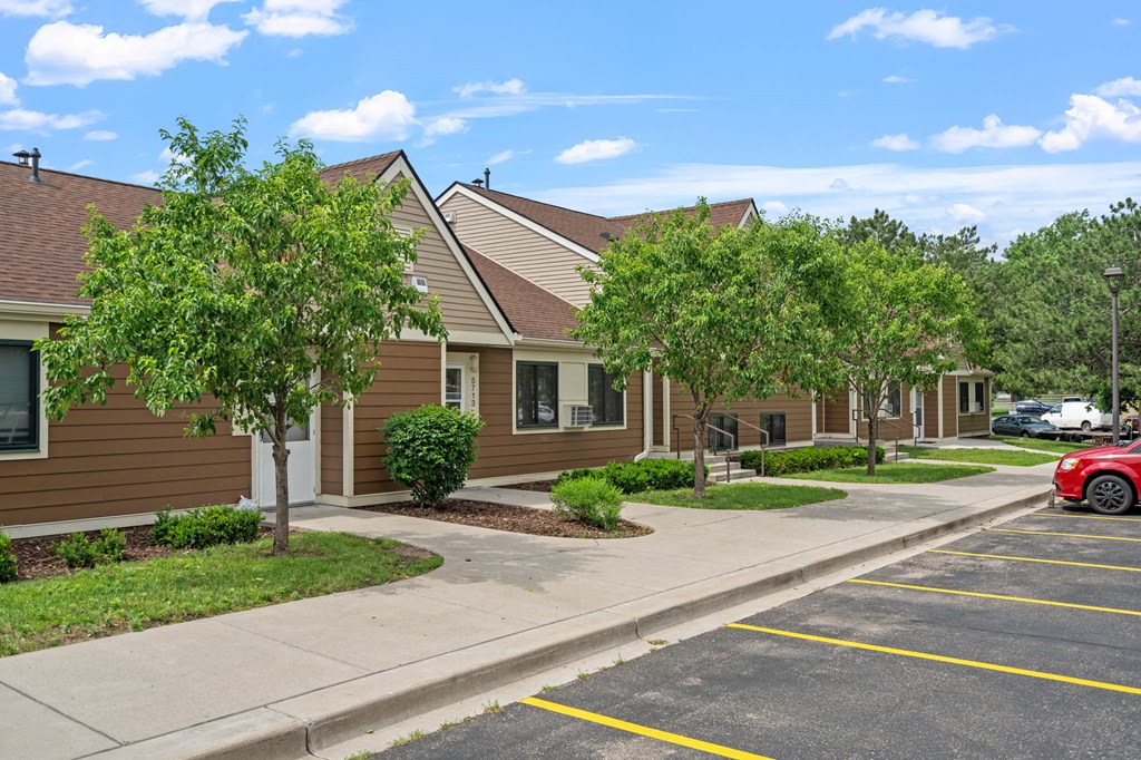a row of houses with trees in front of them on a sidewalk
