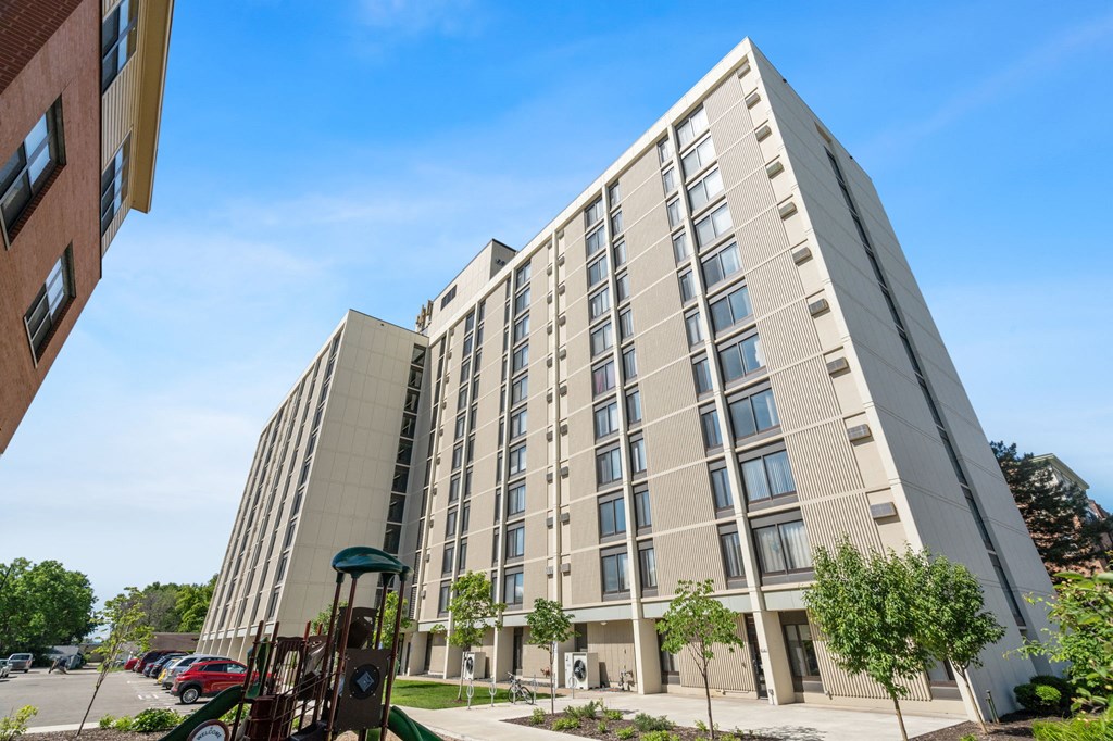 an apartment building with a playground in front of it