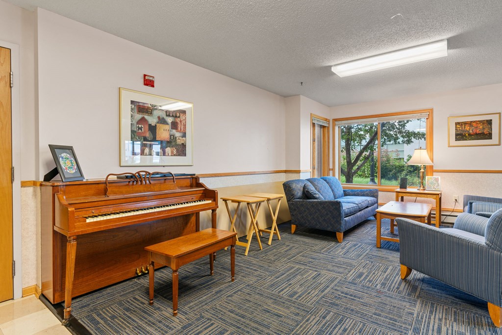 a living room with furniture and a piano