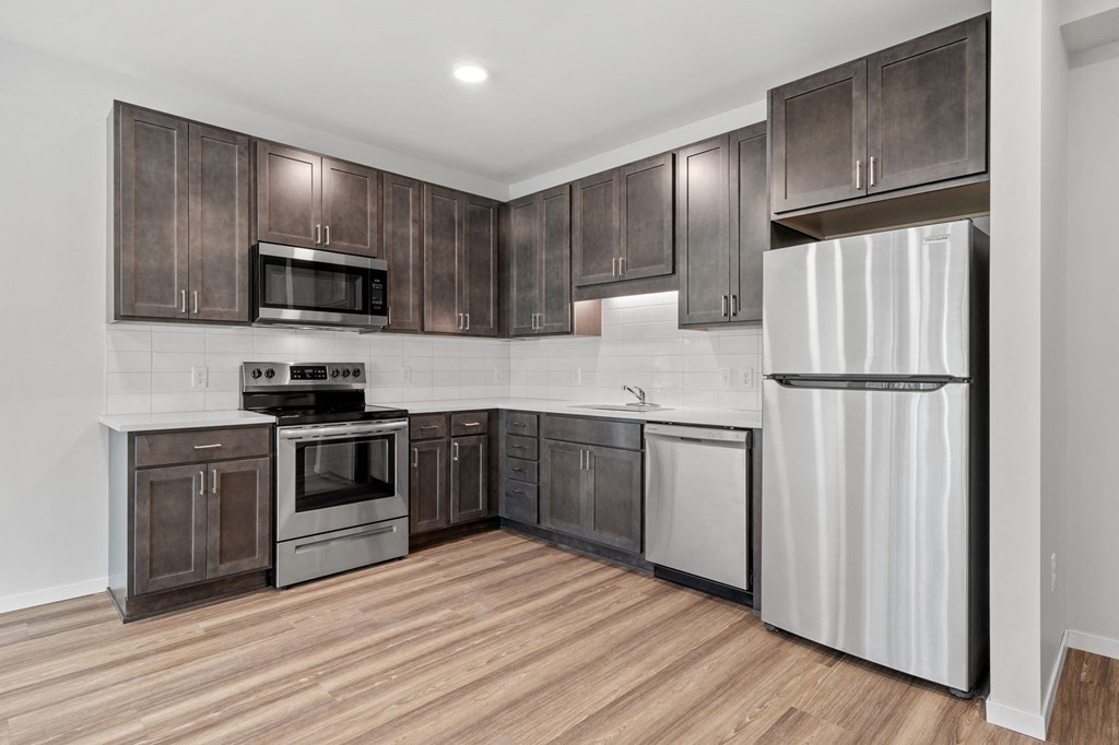 a kitchen with wooden cabinets and stainless steel appliances