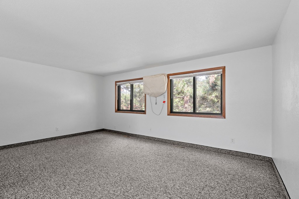 the living room of a house with a window and carpet