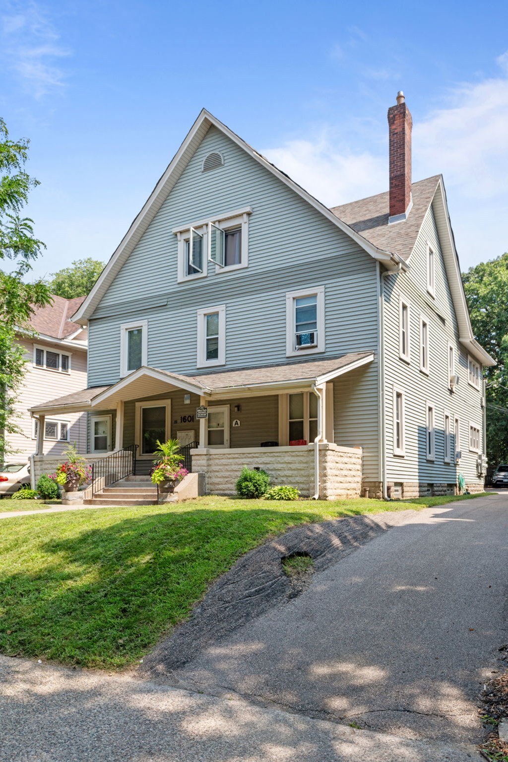 a blue house with a porch and a driveway