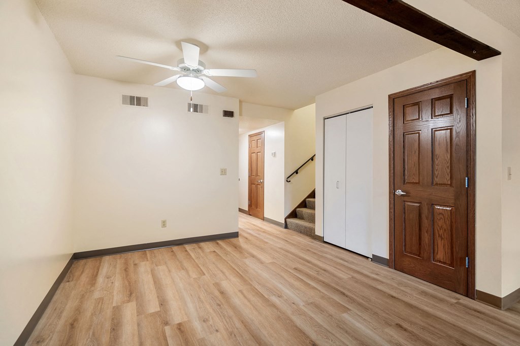 A room with a wooden floor and a ceiling fan.