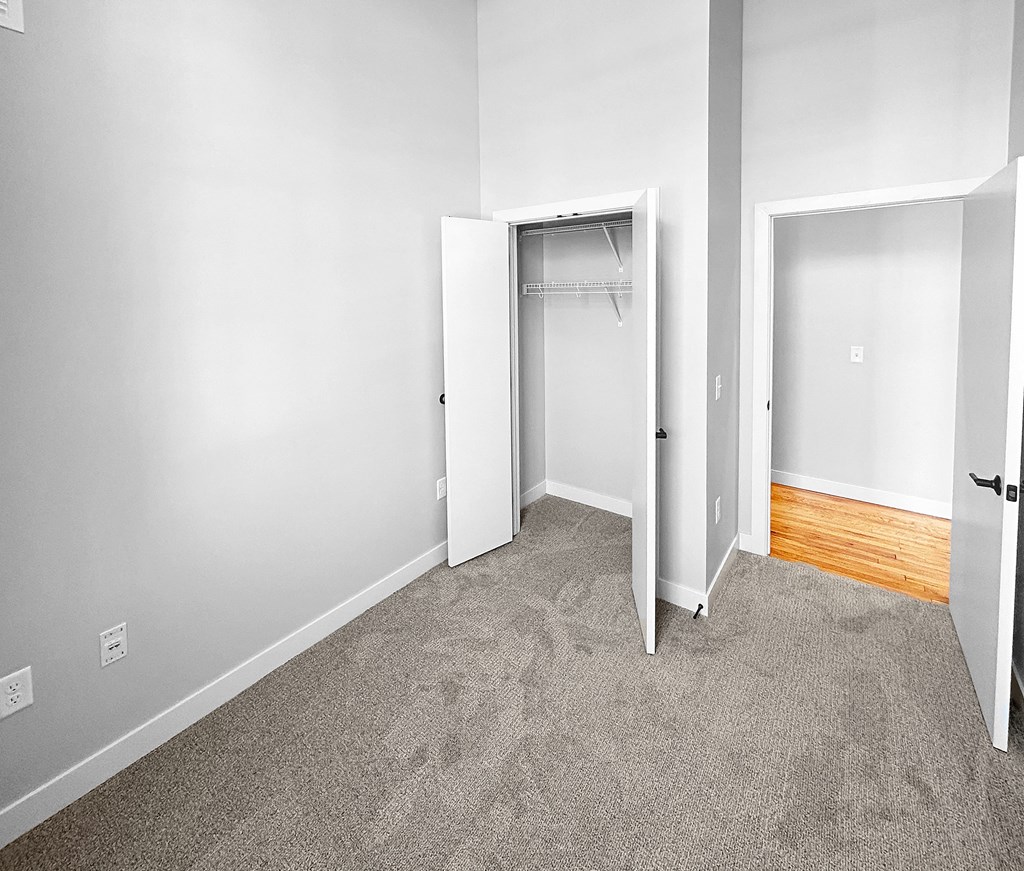 an empty room with carpet and a closet