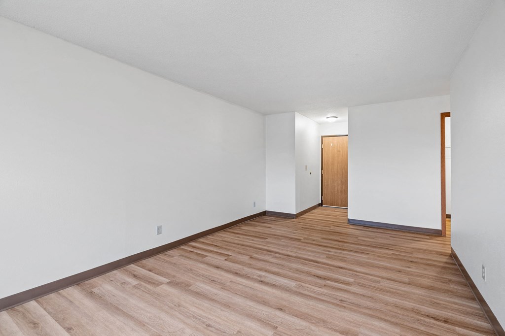 a living room with wood floors and white walls