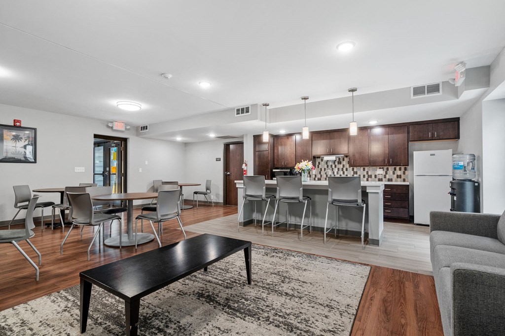 a living room with a kitchen and a table with chairs