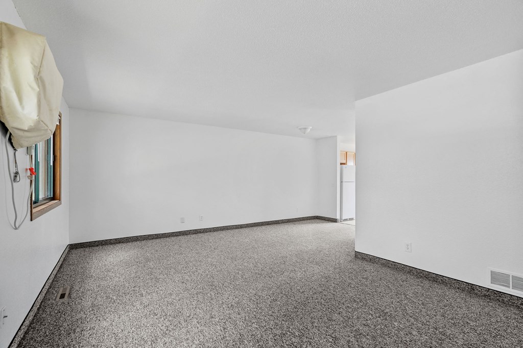 an empty room with carpet and white walls