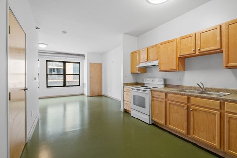 a kitchen with wood cabinets and white appliances and a window