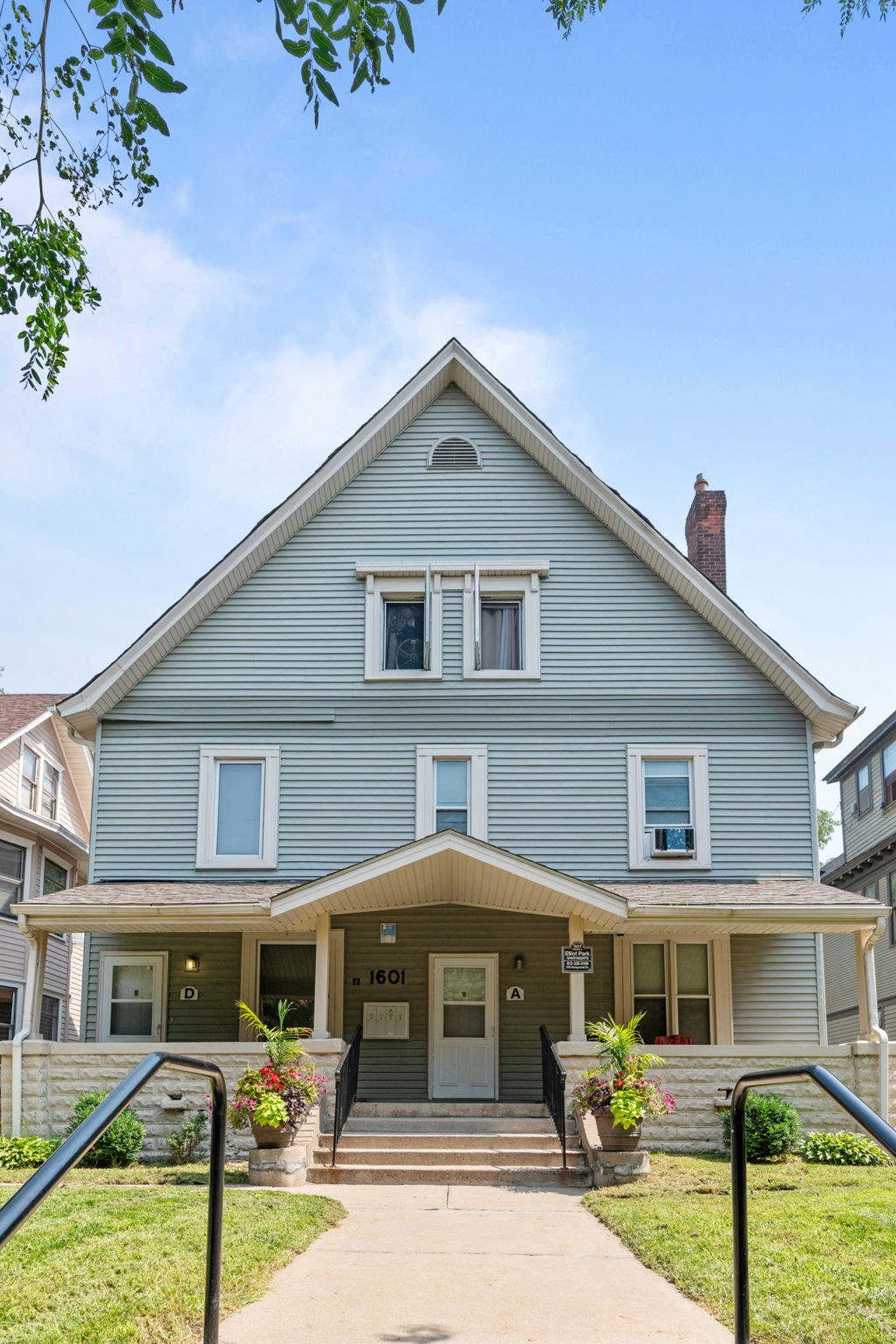 the front of a blue house with a porch and stairs