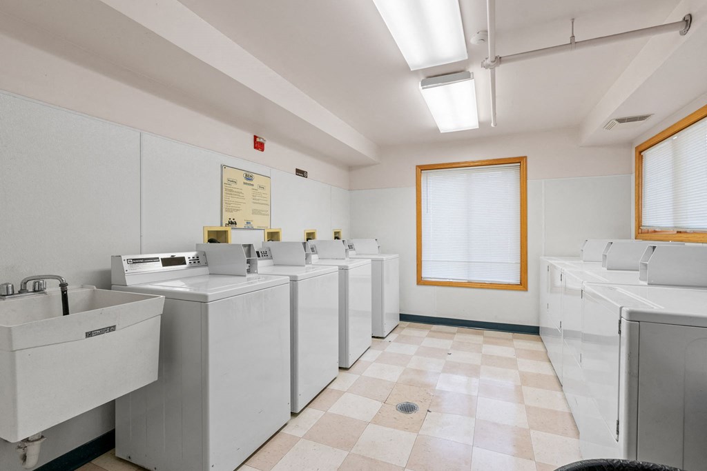 a row of washers and dryers in a laundry room