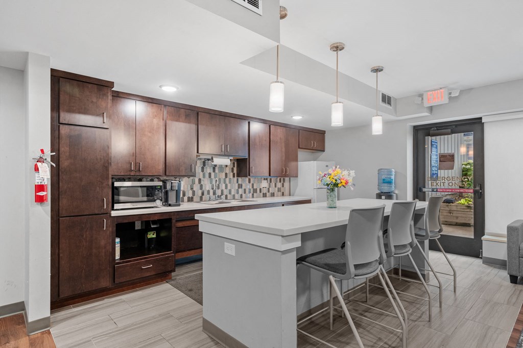 a kitchen with a large island and a bar with chairs