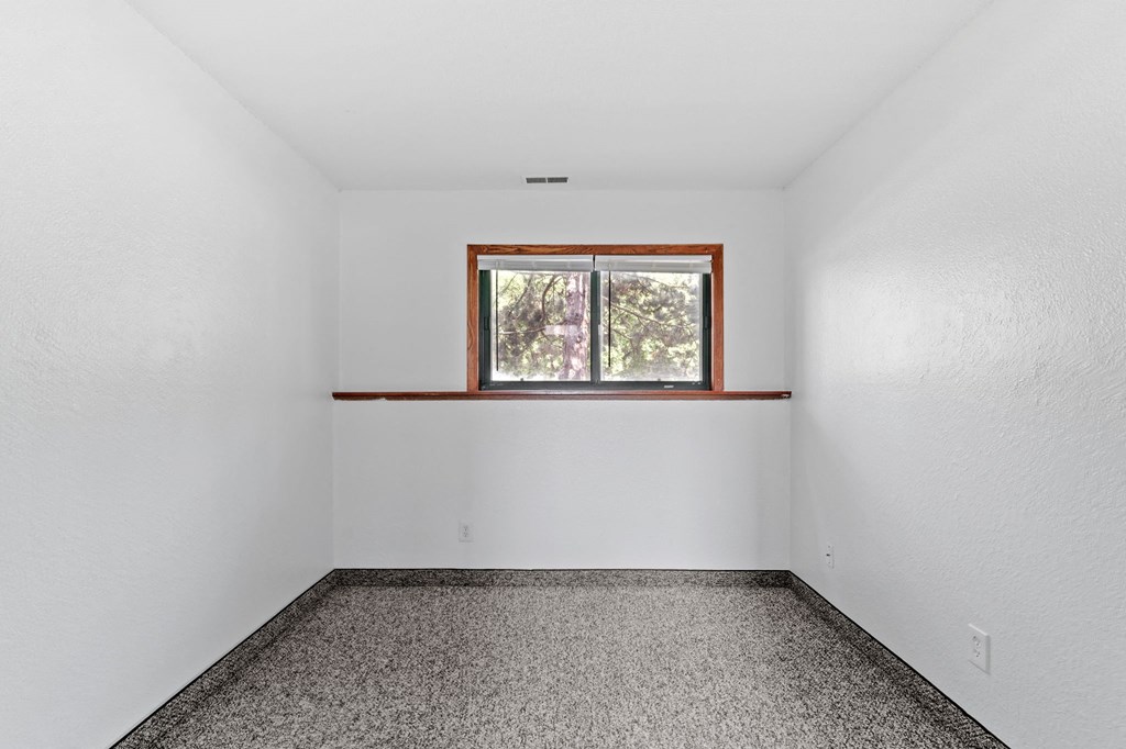 an empty room with a window in the corner