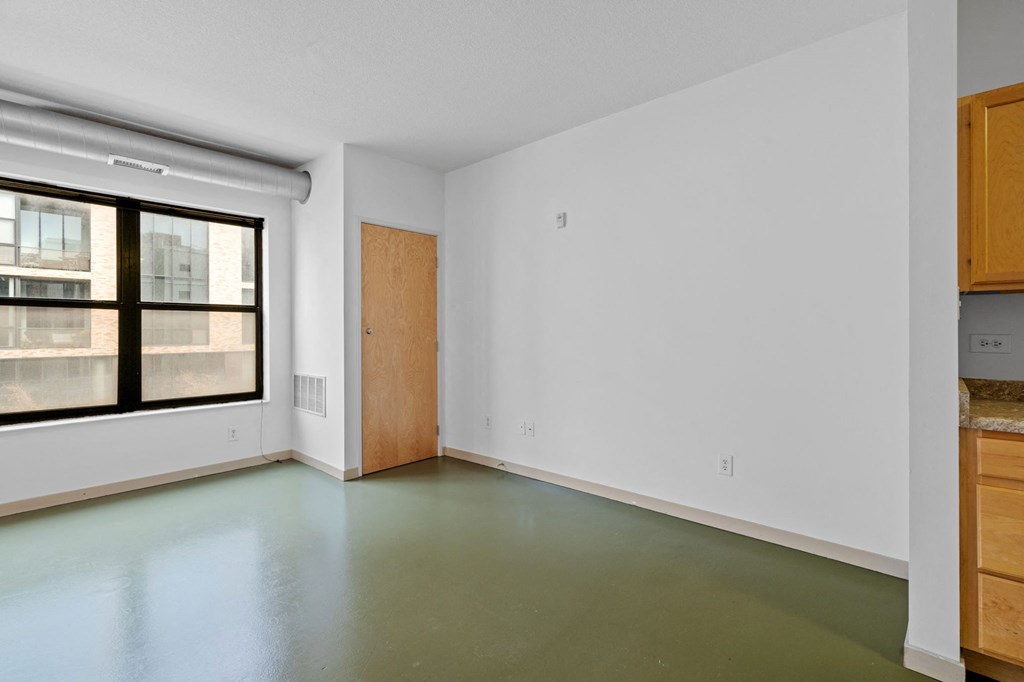 an empty room with white walls and a window