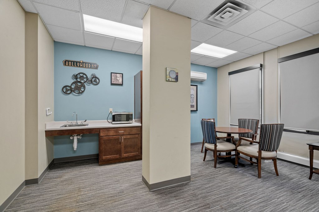 a dining room with a table and chairs and a sink