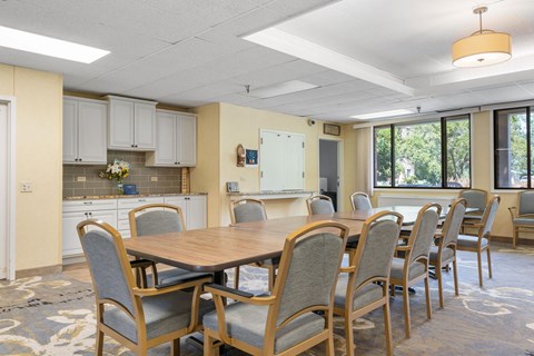 a conference room with a table and chairs and a kitchen