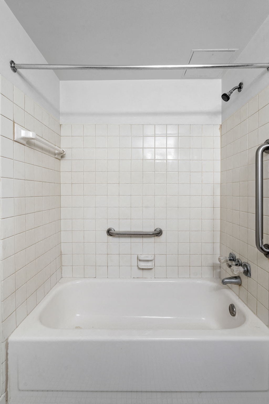 a white tub in a bathroom with white tiles