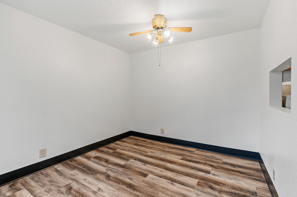 the living room of a home with a wood floor and a ceiling fan