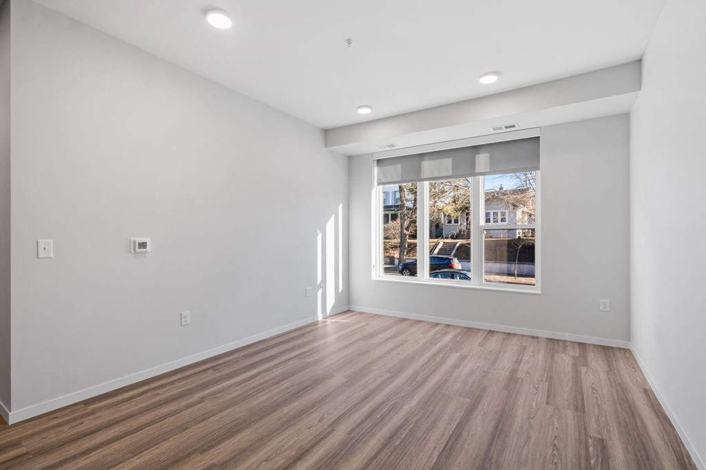 a living room with white walls and a window