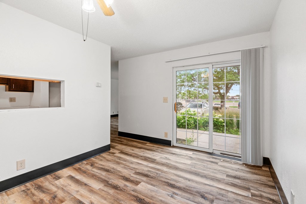 a living room with a door to a balcony and a window