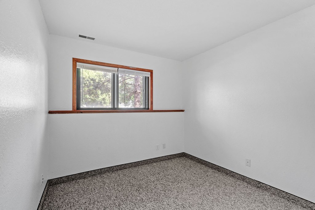 an empty room with a window in the corner