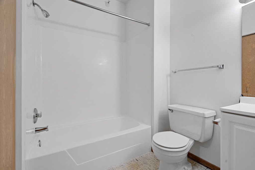 a bathroom with a toilet and a tub and a sink