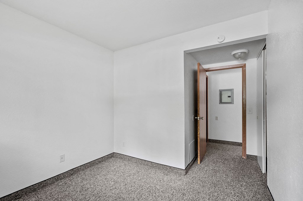 an empty room with white walls and a door to a hallway