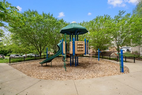 a playground with a swing set and a slide in a park