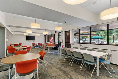 a dining room with tables and chairs and large windows
