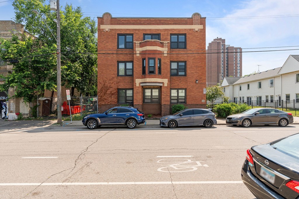 a brick building with cars parked in front of it on a street