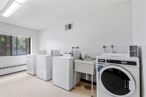 an empty laundry room with washing machines and other appliances