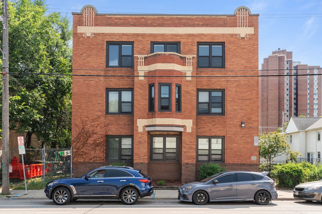 a brick building with cars parked in front of it